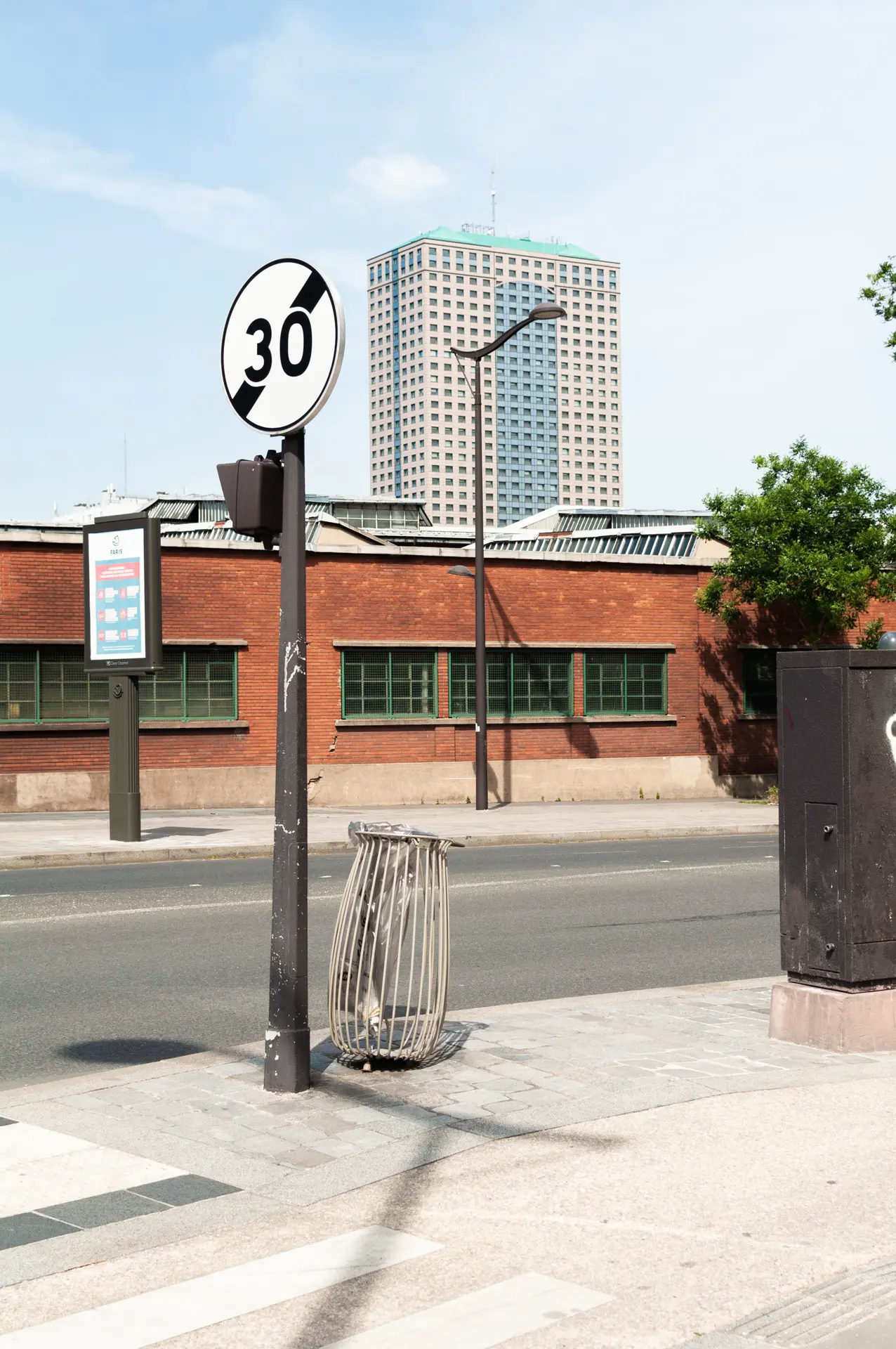 Panneau de limitation de vitesse, poubelle, réverbère, Tour La Villette, ciel. Boulevard Macdonald, Paris 18e.