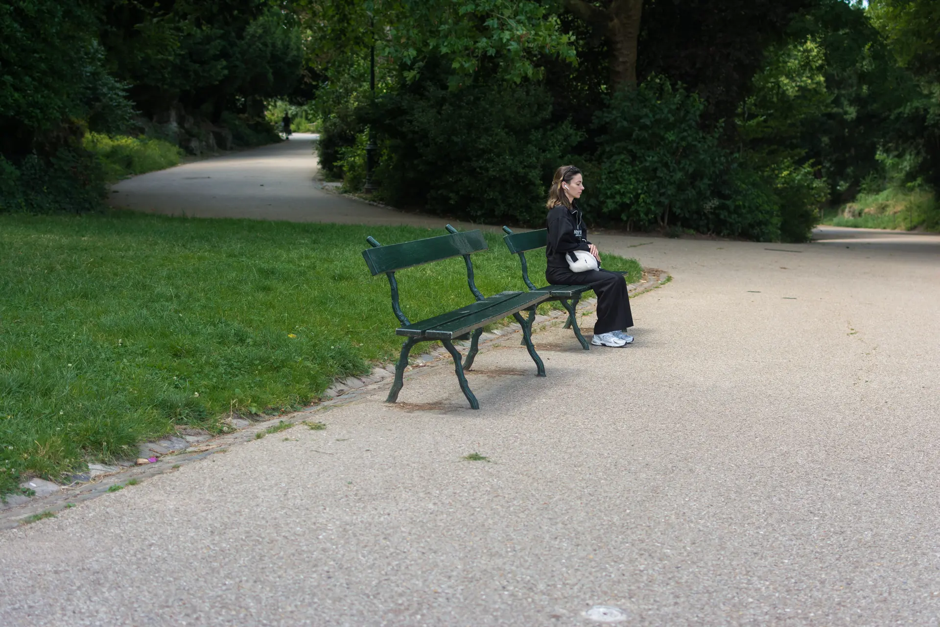 Femme assise sur un banc, parc des Buttes-Chaumont, Paris 19e. Journal du lundi 1er juillet 2024.